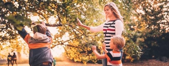 Barnvakt leker i parken med barn